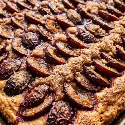 Traditioneller Zwetschgenkuchen mit Hefeteig auf einem Backblech mit goldbraunem Rand